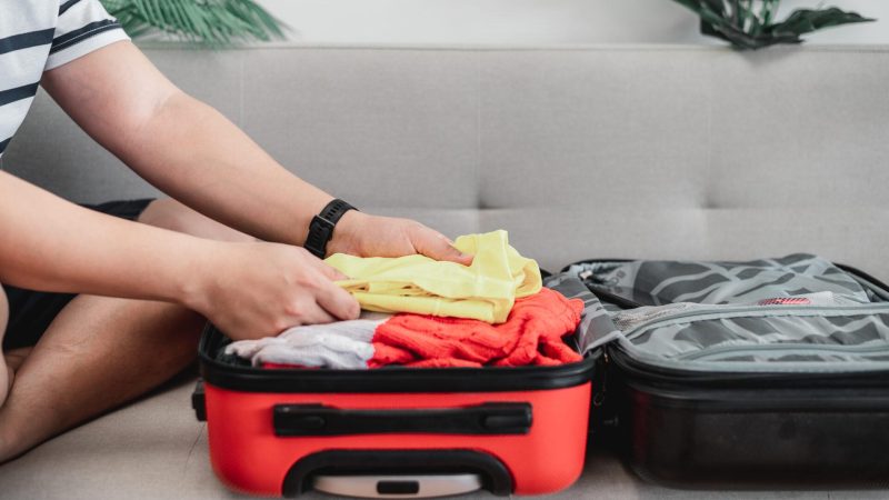 preparando a mala para a viagem de ferias de verao jovem verificando acessorios e coisas na bagagem ferias de viagem e conceito de ferias